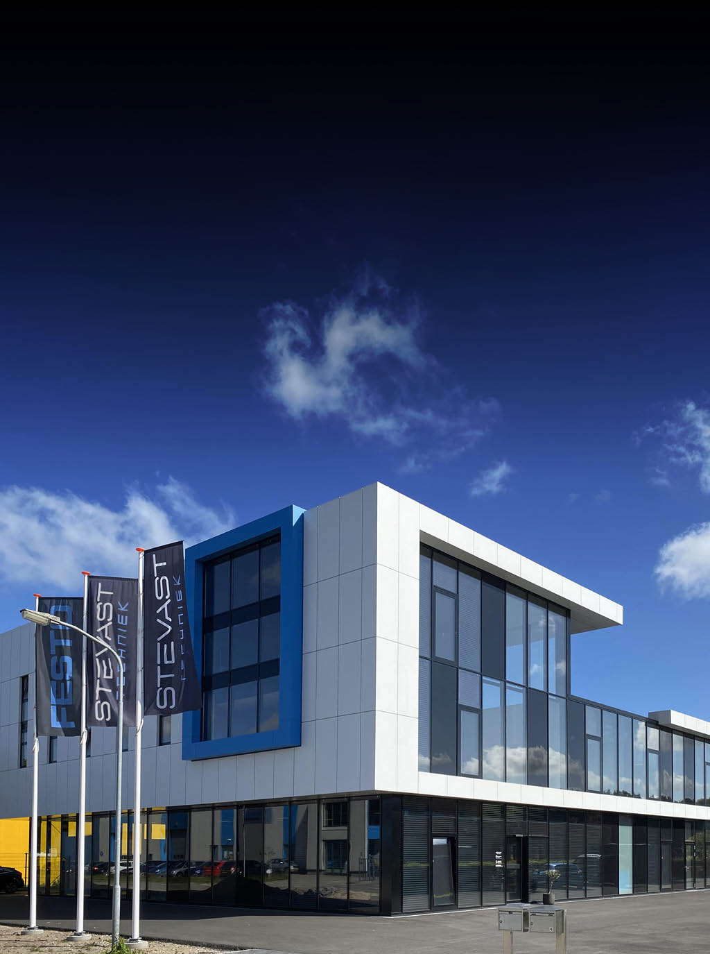 Pand van Stevast Techniek met daarachter een prachtig blauwe lucht.